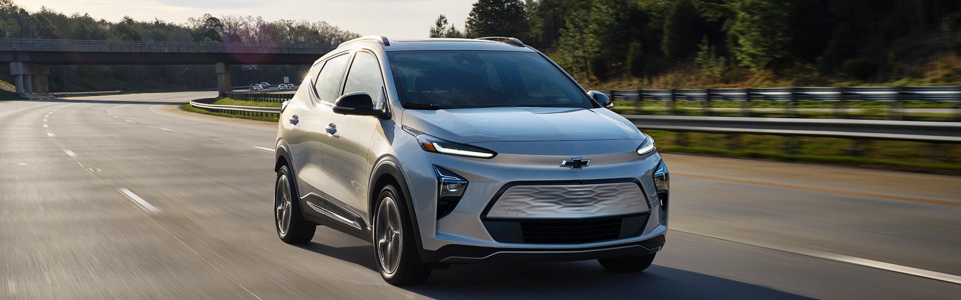 Chevrolet Bolt EUV driving on a highway at sunset