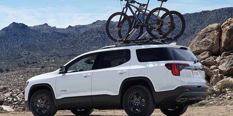 White Acadia carrying cycles on roof