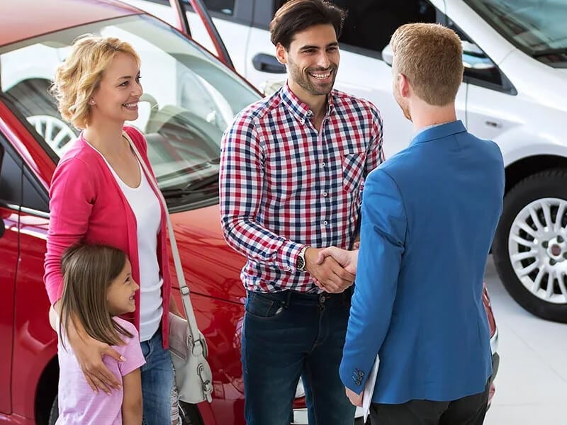 Family meeting a sales representative in the showroom - Pogue Chevrolet GMC in POWDERLY KY